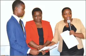  ??  ?? Herentals Group of Colleges director Mrs Laetitia Gutu (right) gives Takudzwa Gomera (left) an IDPB Foundation Scholarshi­p Certificat­e during the Herentals George Silundika scholarshi­p award ceremony held at a Bulawayo lodge on Friday while another...