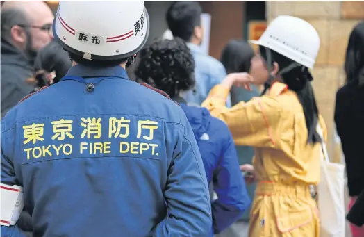  ??  ?? PREPARED FOR ACTION: Residents, office and shop workers at and around the Roppongi Hills shopping complex taking part in a disaster drill in Tokyo.