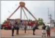  ?? JAY LAPRETE - THE ASSOCIATED PRESS ?? Passers by look at the fire ball ride as Ohio State Highway Patrol troopers stand guard at the Ohio State Fair Thursday, in Columbus, Ohio. The fair opened Thursday but its amusement rides remained closed one day after Tyler Jarrell, 18, was killed and...