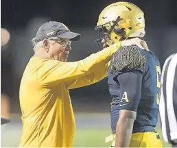  ?? MICHAEL LAUGHLIN/SUN SENTINEL ?? St. Thomas Aquinas athletic director George Smith has a word with running back Daniel Carter during their 7A regional final against Dwyer. Aquinas won 35-0.