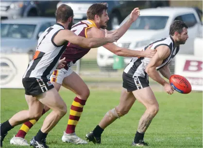  ??  ?? Sale was first to the ball throughout the first half of the game on Saturday as typified by Jamie Sweeney able to get clear with a handball before Drouin coach Bob McCallum could lay a tackle. Photo: Gippsland Times