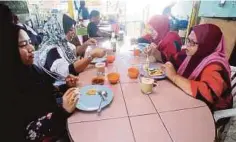  ??  ?? PELANGGAN menikmati roti canai di gerai Mustafa.