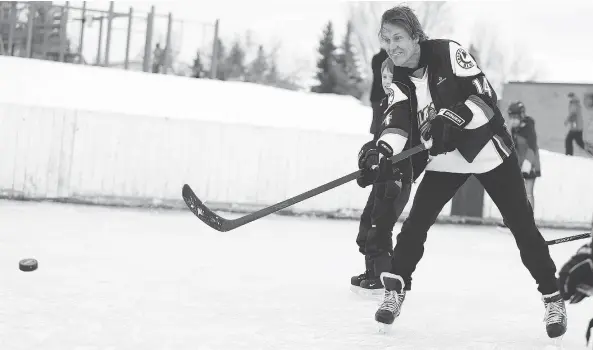  ?? QC PHOTO BY MICHELLE BERG ?? Blue Rodeo’s Jim Cuddy plays shinny with the Blades during the community skate event at the St. George School rink in Lawson Heights in Saskatoon on January 19, 2014.