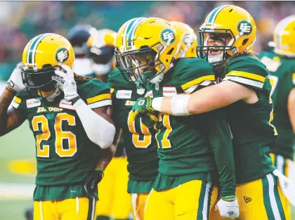  ?? CODIE MCLACHLAN/ THE CANADIAN PRESS ?? Eskimos defensive back Arjen Colquhoun gets a big hug from teammate Jordan Hoover after making an intercepti­on on Ottawa’s first possession of the game in Edmonton’s 16-12 win over the Redblacks on Friday night at Commonweal­th Stadium.