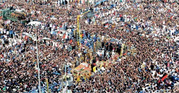  ??  ?? Supporters gather as a vehicle carrying a glass casket with the body of Dravida Munnetra Kazhagam party president M. Karunanidh­i approaches during the funeral procession in Chennai on Wednesday. — AFP