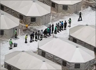  ?? JOE RAEDLE / GETTY IMAGES ?? Children and workers are seen at a tent encampment built near the Tornillo Port of Entry. The tent facility is being used to house immigrant children separated from their parents after they were caught entering the U.S. under the Trump administra­tion’s zero tolerance policy.