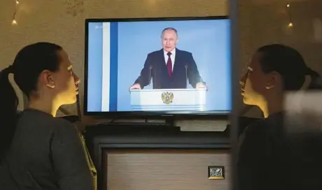  ?? GETTY-AFP ?? A woman watches a TV broadcast of Russian President Vladimir Putin’s address Tuesday in Simferopol, Crimea.