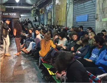  ?? (Jerusalem Post staff) ?? AN AUDIENCE in Jerusalem’s shuk gathers to listen to a Tunisian Jewish Holocaust survivor describe life during WWII in Tunis. The author argues it is important Israel incorporat­e all Jewish cultures and history into its mosaic.