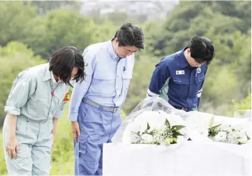  ?? — Reuters photo ?? Abe (centre) pays a silent tribute to the victims of the torrential rain in Kurashiki, Okayama Prefecture, Japan.