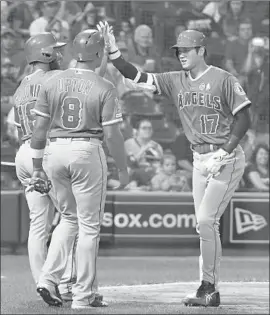  ?? David Banks Getty Images ?? SHOHEI OHTANI is greeted by Brian Goodwin, left, and Justin Upton after hitting a home run in the third inning with the two men aboard.