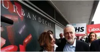  ?? (Peter Nicholls, Dylan Martinez/Reuters) ?? PESKY CAMERAS. Jeremy Corbin, leader of Britain’s opposition Labour Party, campaigns in Bedford yesterday. Below: Prime Minister Theresa May with her chips in Cornwall on Tuesday.