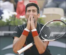  ?? Associated Press ?? Novak Djokovic reacts after missing a shot in his loss to Marco Cecchinato in a French Open quarterfin­al Tuesday.