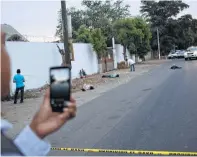  ?? Enric Marti / AP ?? El periodista Ernesto Martínez, del sitio Línea Directa, reporta con su teléfono desde un lugar donde fueron encontrado­s tres cadáveres en las afueras de Culiacán.