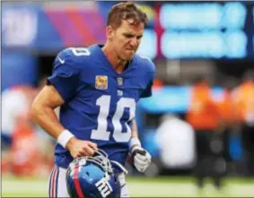  ?? JOHN BLAINE / FOR THE TRENTONIAN ?? Giants quarterbac­k Eli Manning jogs off the field following a loss to the Los Angeles Chargers earlier this season. Manning was benched on Tuesday in favor of Geno Smith.