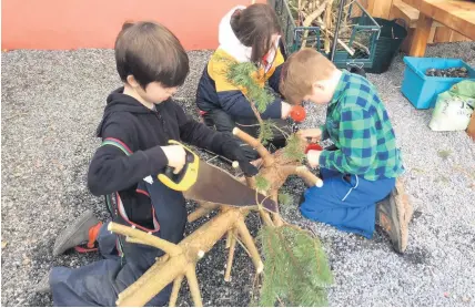  ??  ?? Hands on Glenlyon pupils get a pine branch ready to be part of the Pocket Garden