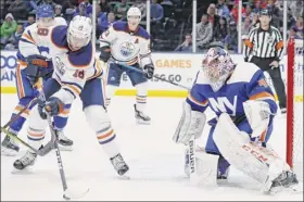 ?? Kathy Willens / Associated Press ?? Oilers’ left wing James Neal, left sets up for a shot in front of Islanders goaltender Semyon Varlamov during Edmonton’s 5-2 road victory.
