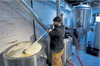  ?? Helen H. Richardson, The Denver Post ?? Alex Buck stirs wort in a mash tun during the brewing process at Black Project.