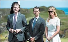  ?? OLI SCARFF/GETTY-AFP ?? Donald Trump plans to turn over management of The Trump Organizati­on to sons Eric, left, and Donald Jr., seen with daughter Ivanka last year at a Trump golf resort in Scotland.