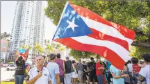  ?? Daniel A. Varela / TNS ?? Miami resident Elisardo Vazquez, 67, waves a Puerto Rican flag during a Saturday protest organized by The Democratic Hispanic Caucus of Florida to demand Puerto Rican Gov. Ricardo Rossello resign.