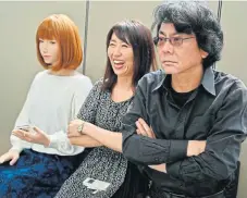  ?? /AFP ?? Machine learnings: Japanese roboticist Hiroshi Ishiguro , right, poses with his assistant next to one of his robots at his research centre in Osaka.