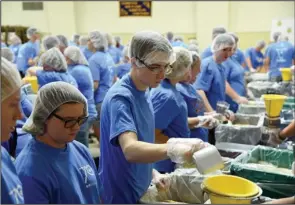  ?? The Sentinel-Record/Grace Brown ?? WORKING TOGETHER: Travis Dobson, center, of Cabot, helps pack 30,000 meals with other members of the Arkansas Future Farmers of America Wednesday at Camp Couchdale.