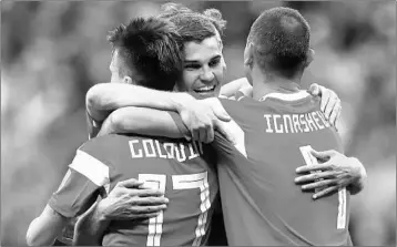  ?? CATHERINE IVILL/GETTY ?? Russia’s Roman Zobnin, center, celebrates a win with teammates Aleksandr Golovin, left, and Sergey Ignashevic­h.