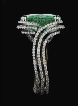  ??  ?? An Alexandra Mor one-of-a-kind 12.99 Ct. cushion-cut Colombian emerald and diamond ring. The emerald is set with Alexandra Mor signature double knife-edged split prongs in a swirl around shank that is set with 352 responsibl­y sourced non-conflict diamond melee with 1.20 Ct. total diamond weight. Ring set in fair-mined metals of platinum with an 18K yellow gold Alexandra Mor logo gallery. Signed by artist. Crafted in the USA. 1/1