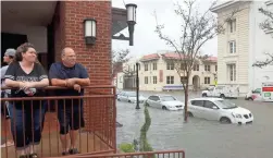  ?? JOE RAEDLE/GETTY IMAGES ?? Heather and Mike Bordeaux look out at a flooded street from their hotel in Pensacola, Fla., after Hurricane Sally roared through.