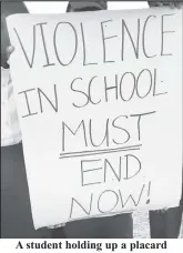  ?? ?? A student holding up a placard