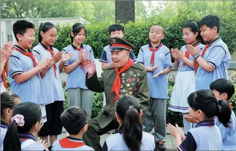  ?? XINHUA DAI DANHUA / ?? Wang Zhanshan tells his stories to students from Sanguanmia­o Primary School in Anyang city, Henan province, on June 11.