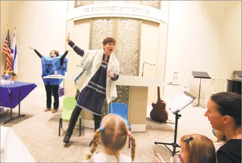  ?? Christian Abraham / Hearst Connecticu­t Media ?? Harriet Dunkerley, a student cantor at Greenwich Reform Synagogue, performs at a “Tot Shabbot” service, above and at left, and discusses her life, far left. Dunkerley lost a cousin in the Tree of Life Synagogue shooting in Pittsburgh in October.