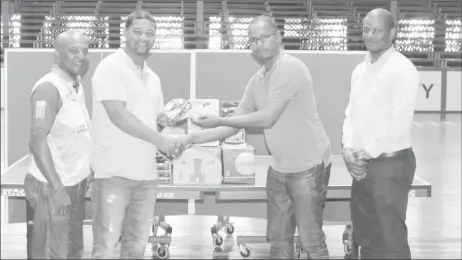  ??  ?? Proprietor of Dominion House, Dwayne Monroe second right hands over his contributi­on to President of BTTSC Timothy Cornelius on Friday. Also in the photo, Godfrey Munroe (right) and Linden Johnson. (Royston Alkins photo)