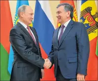  ?? "1 1)050 ?? Russian President Vladimir Putin, left, and Uzbekistan’s President Shavkat Mirziyoyev shake hands ahead of an informal meeting of the CIS (Commonweal­th of Independen­t States) leaders at the Novo-Ogaryovo residence outside in Moscow, Russia.