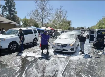  ?? CARLOS GUERRERO — DAILY DEMOCRAT ?? The car wash fundraiser for Tina Vital’s family was held in the parking lot of Pete’s Restaurant And Brewhouse, located at 164 Main St.