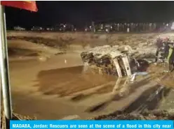  ?? — AFP ?? MADABA, Jordan: Rescuers are seen at the scene of a flood in this city near Amman on Friday.