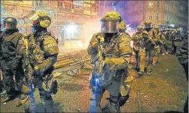  ?? REUTERS ?? Heavily armed police commandos patrol a Hamburg street on Saturday after demonstrat­ors protesting the G20 Summit torched cars and lorries, smashed windows in banks, looted retail stores and hurled paving slabs and other objects. Some 197 officers were...