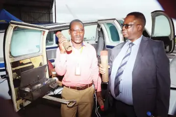  ?? ?? The permanent Secretary in the Ministry of Environmen­t, Climate and Wildlife Professor Prosper Matondi (right) and Department of Meteorolog­ical Services cloud seeder, Christophe­r Masunda hold cloud seeding cartridges at the launch of the 2024 cloud seeding programme at Charles Prince Airport in Mt Hampden, Harare, yesterday. — Picture: Kudakwashe Hunda