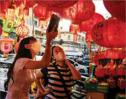  ?? CINDY LIU / GETTY IMAGES ?? Customers shop for Lunar New Year lanterns on Jan 22 at a store in Phnom Penh, Cambodia. Holiday preparatio­ns are also underway in countries such as Malaysia and Indonesia.