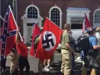  ??  ?? 白人至上主义者打着纳­粹旗帜游行示威