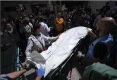  ?? Fatima Shbair/Associated Press ?? Members of the World Central Kitchen aid group transport the body of one of the six foreign aid workers who were killed in an Israeli strike Wednesday, in Rafah.