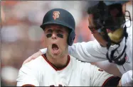  ?? NHAT V. MEYER/TRIBUNE NEWS SERVICE ?? Top left: Buster Posey (28) sits on the ground after taking a pitch in his helmet during a game against the Arizona Diamondbac­ks on Monday in San Francisco. Above right: San Francisco Giants players are introduced during opening day pregame ceremonies....