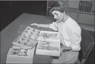  ?? ASSOCIATED PRESS ARCHIVES ?? In an undated photo, Ruth Parrington, librarian in the art department of the Chicago Public Library, studies early Sears Roebuck catalogs. The catalog Parrington is holding features women’s fashion from 1902.