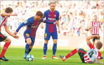  ??  ?? Barcelona's Lionel Messi (2L) vies with Athletic Bilbao's Inigo Martinez (down) during their match at the Camp Nou stadium in Barcelona.