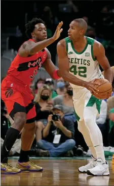  ?? STUART CAHILL / BOSTON HERALD ?? Al Horford looks for the pass under coverage of Raptors forward OG Anunoby during the Celtics home opener at TD Garden on Friday night.