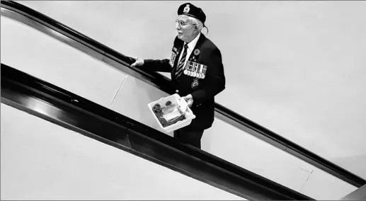  ?? DARREN CALABRESE/ CP FILE PHOTO ?? Canadian war veteran Al Leadbeater, 84, rides the elevator after returning from replenishi­ng his poppy stocks for sale at Halifax Internatio­nal Airport last week.