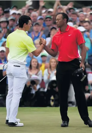  ?? GETTY ?? Friendly rivals: Rory Mcilroy and Tiger Woods shake hands on the 18th green during the final round of the 2015 Masters