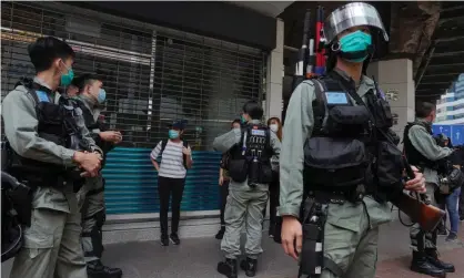  ?? Photograph: Vincent Yu/AP ?? Riot police check a pedestrian in Causeway Bay, Hong Kong.