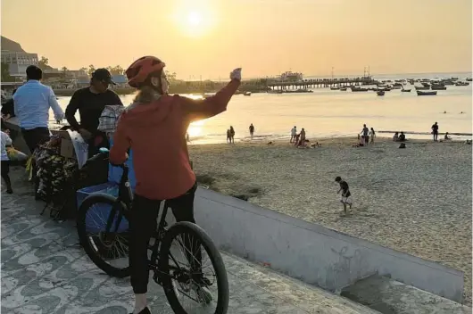  ?? COLLEEN THOMAS/TNS ?? Cyclists on a bike tour stop to gaze at the view along the oceanfront in Lima, Peru.