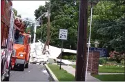  ?? BOB KEELER — MEDIANEWS GROUP ?? Lansdale Electric crews evaluate damage from a roof blown off by heavy winds at the Crossing at Stanbridge.