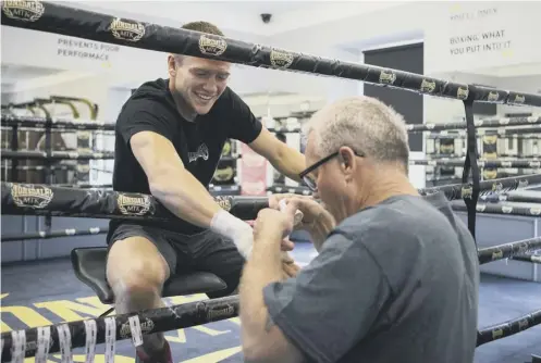  ??  ?? 0 World-renowned trainer Freddie Roach tapes up the right hand of Ivan Baranchyk as the Belarusian prepares to face Josh Taylor.